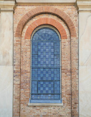 Fototapeta na wymiar arch window against brick wall in old building