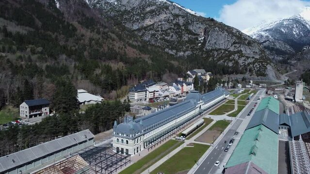 Aerial rotates over classic train station in Pyrenees mountains, Spain