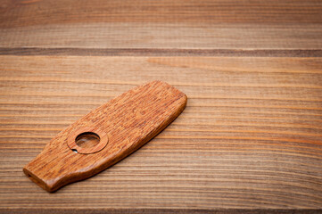 Kazoo is a musical wind instrument made of wood, filmed on a wooden surface.