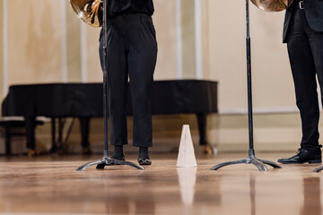 A wooden French horn mute next to a musicians feet during a performance