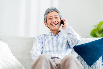 笑顔で電話をかける日本人シニア