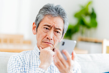 携帯を持ち困る日本人男性