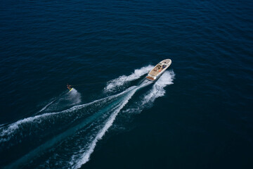 Aerial view of a man wakeboarding on the water. Water skiing on the water behind the boat.