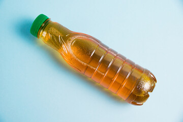 Apple juice in a plastic bottle on a blue background. Concept of earth day, zero waste and plastic...