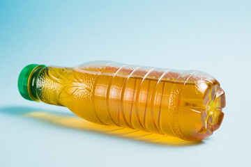 Apple juice in a plastic bottle on a blue background. Concept of earth day, zero waste and plastic...