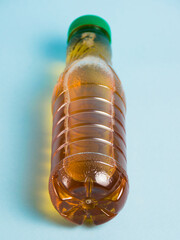 Apple juice in a plastic bottle on a blue background. Concept of earth day, zero waste and plastic...