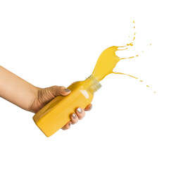 Women hand holding smoothie of juice bottle with yellow liquid with splashing, isolated without...