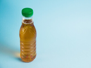Juice in a plastic bottle on a blue background. Concept of earth day, zero waste and plastic recycling.