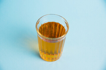 Glass of juice on blue paper background. Concept of healthy eating.