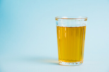 Glass of juice on blue paper background. Concept of healthy eating.
