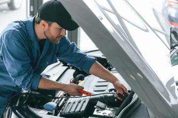 Man in blue uniform is working in the car service