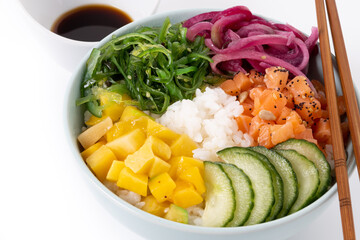 Poke bowl with rice, salmon,cucumber,mango,onion,wakame salad, poppy seeds ands sunflowers seeds isolated on white background