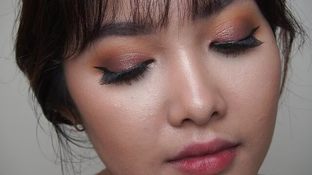 Beauty slow motion shot of a pretty Asian woman with natural make up