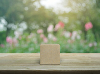Wood block cube on wooden table over blur pink flower and tree in park