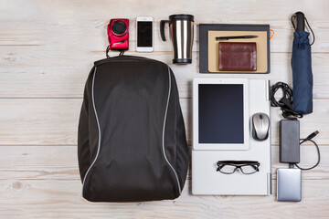 Flatlay Concepts. Top View of Backpack With Laptop and Tablet Nearby, Mobile Phone With Notebook and Accessories Over Wooden Background. Concept of Travel Life Accessories