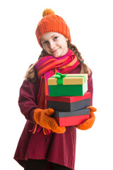 Winsome Happy Caucasian Little Girl In Orange Beanie Hat, twirling Scarf and Mittens With Pile of Colorful Giftboxes. Isolated Against Pure White