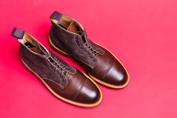 Upper View of Pair of Premium Dark Brown Grain Brogue Derby Boots Made of Calf Leather with Rubber Sole Placed On Pink