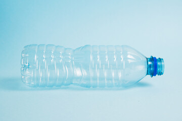 Transparent plastic bottle on the blue background. Concept of earth day, zero waste and plastic recycling.