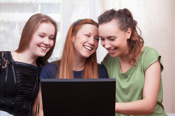 Modern Youth Lifestyle. Three Young Happy Laughing Caucasian Girlfriends With Personal Laptop Computer
