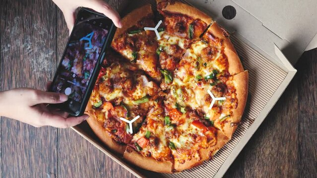 Woman hands taking photos of pizza.