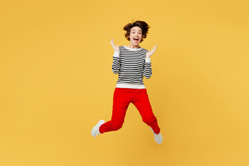 Fototapeta na wymiar Full body overjoyed excited exultant fun young woman wear casual black and white shirt jump high look camera spread hands isolated on plain yellow color background studio portrait. Lifestyle concept.