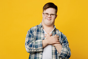 Young smiling thankful man with down syndrome wearing glasses casual clothes look camera put folded...