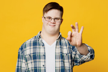 Young fun satisfied positive man with down syndrome wearing glasses casual clothes look camera show...