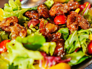 a plate of hot salad with caramelized meat.