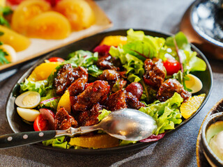 a plate of hot salad with caramelized meat.