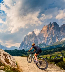 Peel and stick wall murals Dolomites Woman ride electric mountain bikes in the Dolomites in Italy. Mountain biking adventure on beautiful mountain trails.
