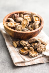 Dried shiitake mushrooms in bowl on kitchen table.