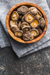 Dried shiitake mushrooms in bowl on kitchen table. Top view.
