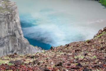 Red soil and azure water in Iceland neat Hafragilsfoss waterfall at Jokulsa a Fjollum river