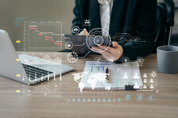 Business woman hand Project manager working and update tasks and Gantt chart scheduling virtual diagram.with tablet and laptop in office.