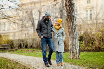Fototapeta premium Embraced romantic couple enjoying a walk in the park
