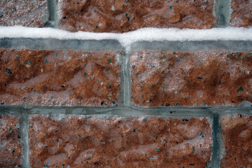 Brickwork made of red brick, covered with an ice crust, cataclysms of nature, the consequences of...