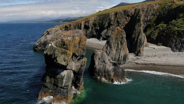 Waves breaking on the Trefor Sea stacks with hovering seabirds on the breathtaking Llyn Peninsula