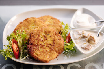 Fried grated potatoes served with mushroom sauce and sour cream. Tasty Ukrainian dish
