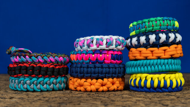 Lots of braided paracord bracelets on a blue background. Handmade, creative design.