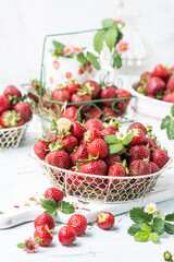 Ripen fresh strawberries in white braided metal container on white background, fresh homegrown  berries served to eat, fresh fruit and food concept