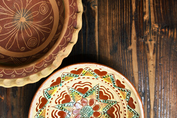 Ukrainian folk traditional ceramics plates top view on a wooden table