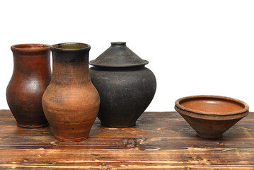 Ukrainian traditional vintage clay kitchenware on wooden table. Rural clay pots, jug and bowl.