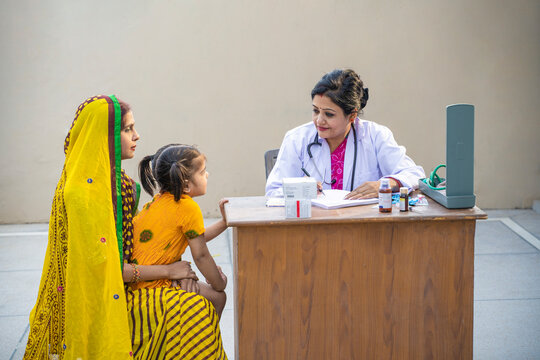 Indian female doctor checking little child patient at village.