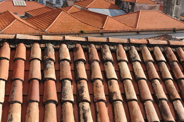 Red and orange roof tiles texture pattern on roof of an old historical building