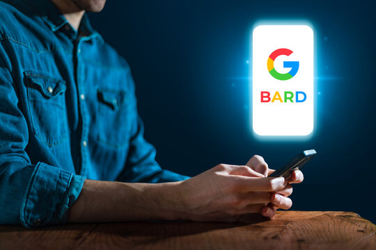 Google Bard AI search bot concept. Conversational artificial intelligence chatbot. Man chatting with bot on smartphone in dark blue technology environment.