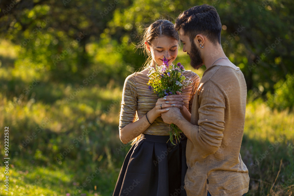 Wall mural man giving wild flowers to his girlfriend