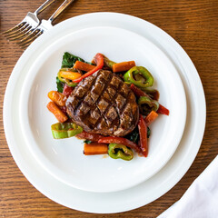 Grilled beef steak and vegetables on a white plate. Grilled beef steak with sauce. 