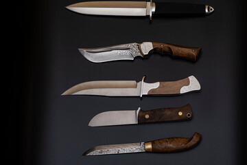 Damascus steel knives on a black background. Kitchen knives. background with japanese knife. A set...
