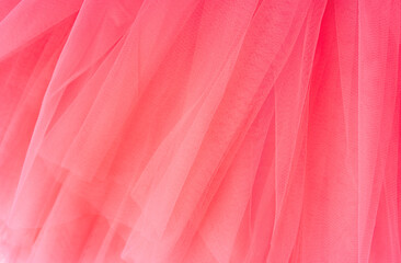 Pink background of tulle fabric close-up.