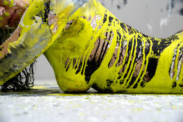 side view of upper body of young sexy naked woman in black, white and light green paint color painted, lies decorative, elegant on the Studio floor. Creative, abstract bodypainting, Copy space